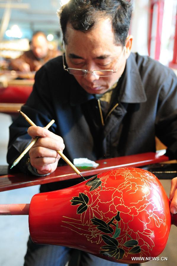 Craftsman Sheng Jihao makes drawings on a bodiless lacquerware in Fuzhou, capital of southeast China's Fujian Province, Dec. 27, 2012. (Xinhua/Lin Shanchuan)