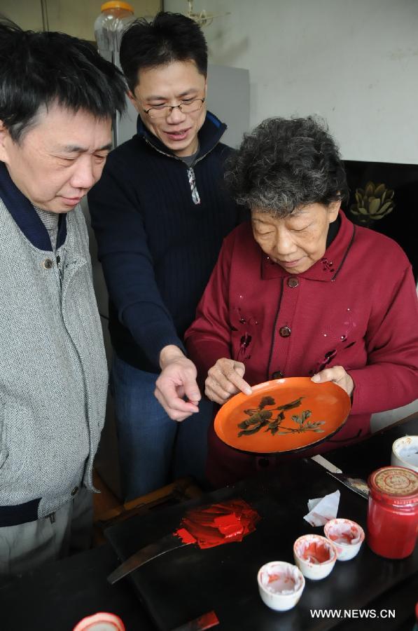 Craftswoman Wu Shouduan (R) discusses bodiless lacquerware techniques with her students in Fuzhou, capital of southeast China's Fujian Province, Dec. 26, 2012. (Xinhua/Lin Shanchuan)