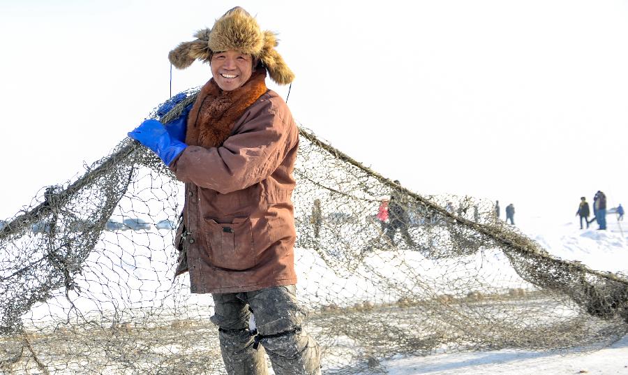 A local fisherman poses for a photo during an ice fishing event in the Chagan Lake in Qian Gorlos Mongolian Autonomous County, northeast China's Jilin Province, Dec. 27, 2012. (Xinhua/Wang Haofei)