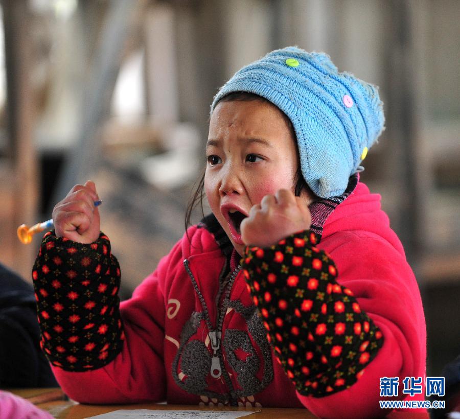 Growth is achieved by strong will: Eight-year-old Feng Yanping is in the classroom in a village of Guangxi Zhuang Autonomous Region, Jan. 9, 2012. Despite freezing weather, students living in mountainous areas of Guangxi didn’t retreat but stayed in classroom. (Xinhua/Huang Xiaobang) 