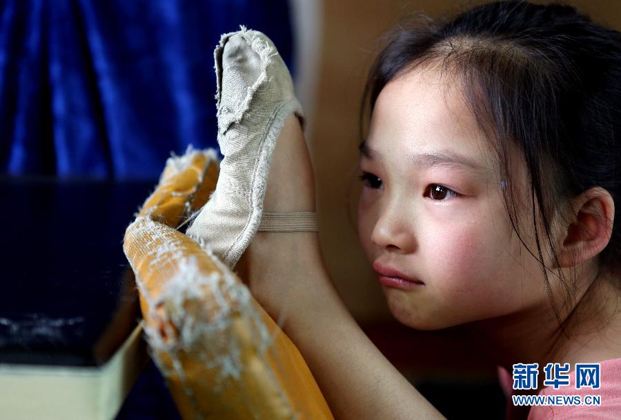 Growth is achieved by endurance: Nine-year-old Zhao Yue stretches legs in silent tears in an acrobat school in Shenyang, May 30, 2012. With dream of being onstage, the students have to endure six-year-long intensive and strict training. (Xinhua/Yao Jianfeng)