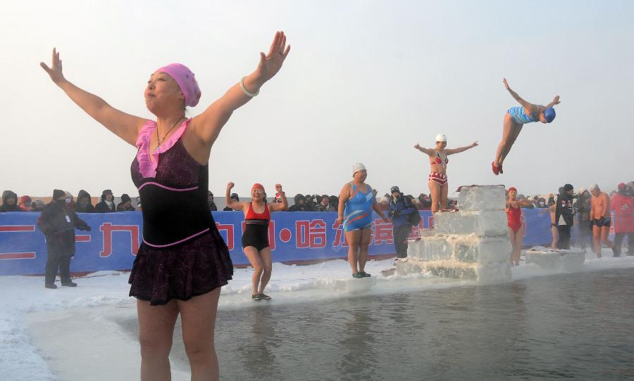 Winter swimmers perform diving in queue in Harbin, capital of northeast China's Heilongjiang Province, Jan. 1, 2013. Over 2,000 tourists from home and abroad watched the winter swimming performance here on Tuesday, the New Year's Day. (Xinhua/Liu Yang)