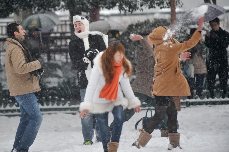 Chinese and foreign tourists throw snowballs near the West Lake in Hangzhou, capital of east China's Zhejiang Province, Jan. 4, 2013. Citizens and tourists enjoyed the snow-covered landscape of West Lake here on Friday after northern and central Zhejiang received continuous snowfall since this Thursday. (Xinhua/Huang Zongzhi)