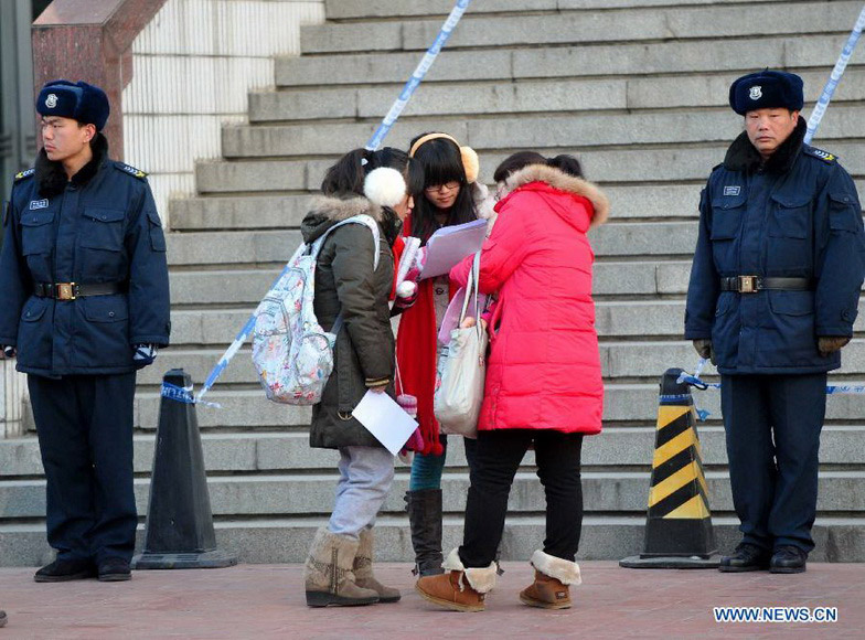 Candidates gather to review books before sitting the National Entrance Examination for Postgraduate (NEEP) outside North China University of Technology in Beijing, capital of China, Jan. 5, 2013. Examinees to take the exam on Jan. 5 are expected to hit a record high of 1.8 million this year. (Xinhua/Gong Lei)