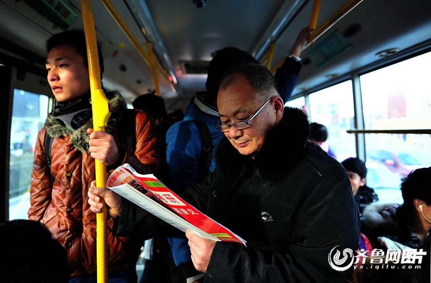 Zhang Shanxue reviews NEEP book on the bus. (Photo/yx.iqilu.com)