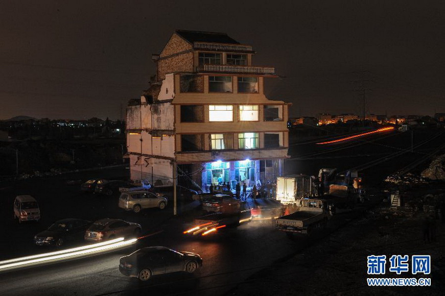 "Most stubborn nail household" moves out: The “most stubborn nail household” - Luo Baogen’s family prepares to move out the five-story building that stands abruptly in the middle of a half-constructed road near the rail station in Wenling, Zhejiang on Nov. 30, 2012. The house was demolished on Dec. 1, 2012. Luo Baogen signed the relocation agreement with the local government and agreed to demolish this five-story building. (Xinhua/Han Chuanhao)