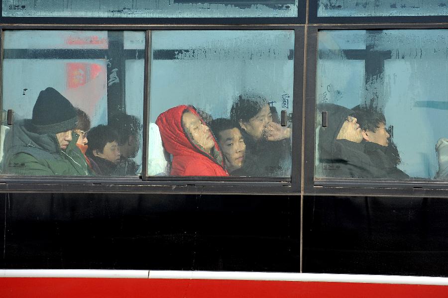 Passsgngers dressing in warm clothes sit in a bus in Taiyuan, north China's Shanxi Province, Jan. 5, 2013. Jan. 5 is the Slight Cold, the 23rd solar term according to the traditional Chinese lunar calendar, ushering in the coldest period in China. (Xinhua/Zhan Yan) 