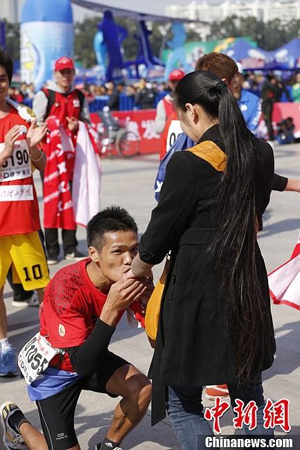 A man proposes to his girlfriend after finishing entire journey of 11th Xiamen International Marathon on Saturday morning. (Chinanews/ Du Yang)