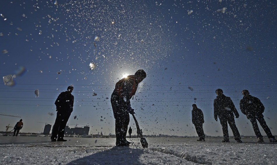 A man digs on the thick ice for an upcoming ice fishing event in northwest China’s Ningxia, Dec. 29, 2012. (Xinhua/Wang Peng)