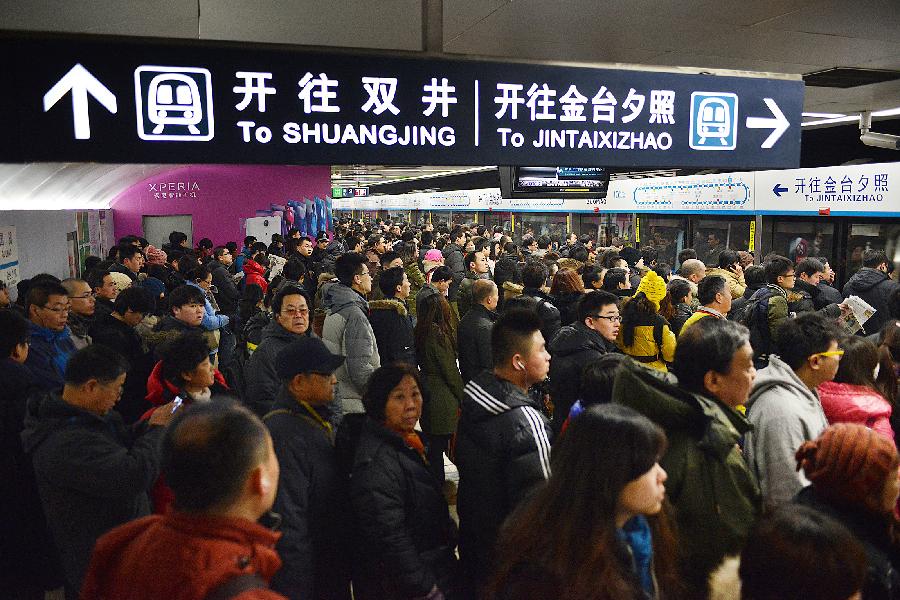 Commuters wait to board a train of subway line 10 at the Guomao Station, in Beijing, capital of China, Jan. 7, 2013. Subway line 10 has reached a daily transportation of 1 million passengers on average, just a week after Phase II's opening that completed a loop for former line 10. Subway line 10 is expected to become the busiest line in Beijing. (Xinhua/Wang Quanchao)