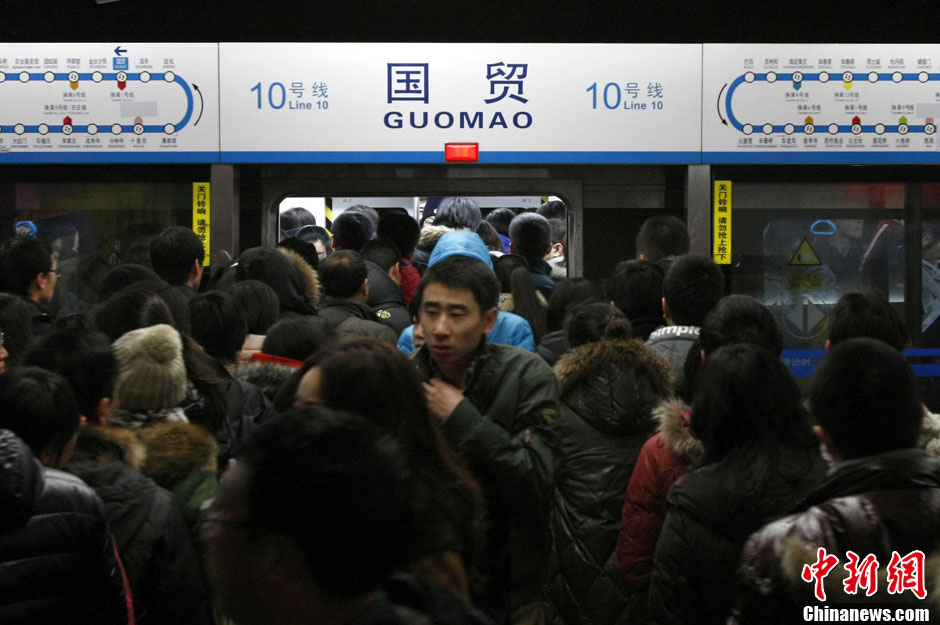 Commuters are pictured in a train of subway line 10 at the Guomao Station, in Beijing, capital of China, Jan. 7, 2013. Subway line 10 has reached a daily transportation of 1 million passengers on average, just a week after Phase II's opening that completed a loop for former line 10. Subway line 10 is expected to become the busiest line in Beijing. (Xinhua/Wang Quanchao)