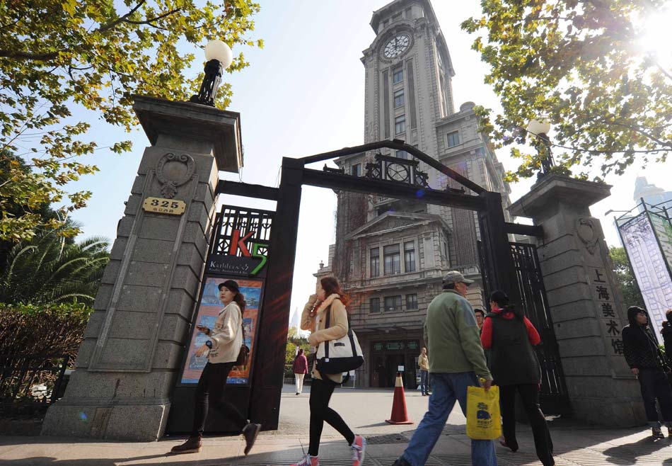 People pass in front of the Shanghai Art Museum on Nanjing West Road on Nov. 11, 2012. The site of Shanghai Art Museum would be closed on Dec. 31 2012 and the museum will be moved to a new place. With the closed date approaching, more and more people came to visit the museum.(Xinhua)