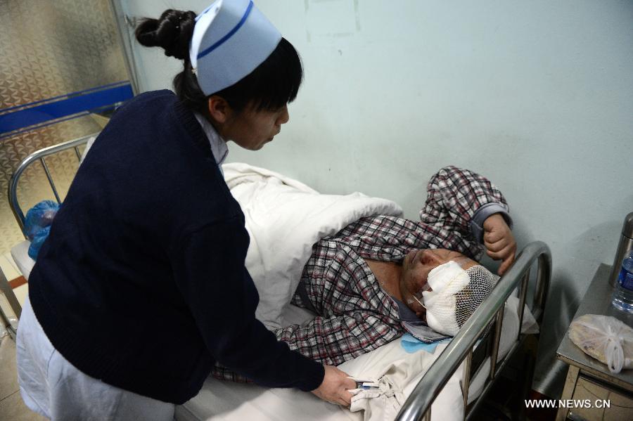 A nurse takes care of a man who got injured in a blast in a hospital in Shuangyashan City, northeast China's Heilongjiang Province, Jan. 11, 2013. (Xinhua/Wang Kai)