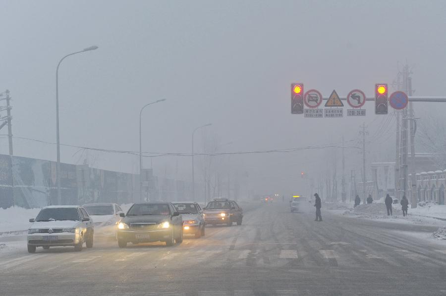 Vehicles are seen on a fog-enveloped street in Changchun, capital of northeast China's Jilin Province, Jan. 13, 2013. Heavy fog hit Changchun on Sunday. (Xinhua/Zhang Nan) 