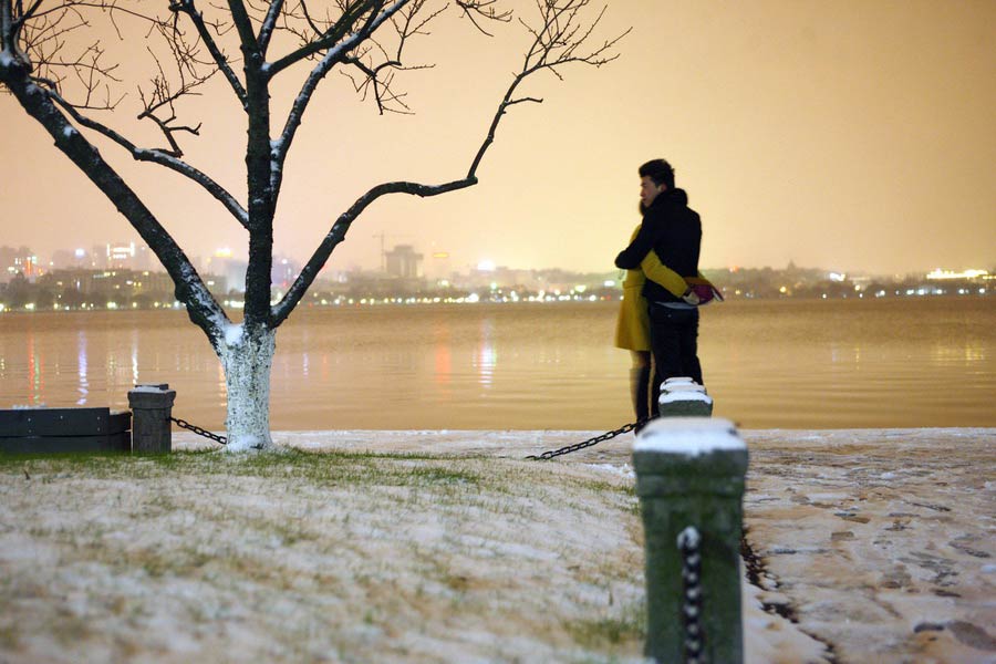 Two lovers huge each other in snow on the dyke of the West Lake, Hangzhou on Jan. 3, 2013. (Xinhua/Cui Xinyu)