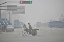 A man rides on a fog-shrouded road in Liuzhou City