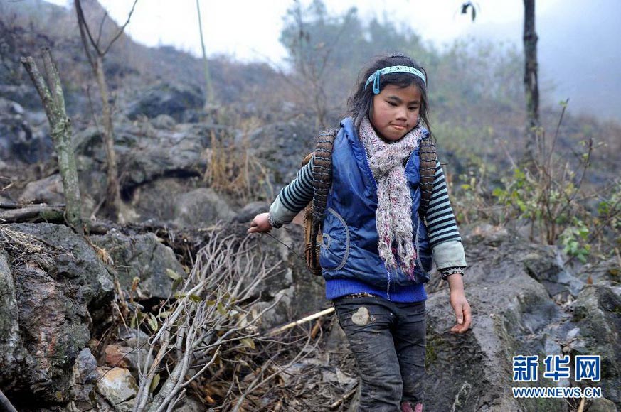 Li Azuo picks up firewood in a village in Guangxi on Jan. 8, 2013. (Xinhua/Zhou Hua)