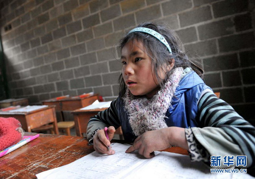 Li Azuo does homework in school to save time for housework in a village in Guangxi, Jan. 8, 2013. (Xinhua/Zhou Hua). 