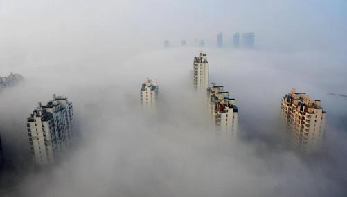 Skyscrapers are partly seen amid thick fog in Suzhou