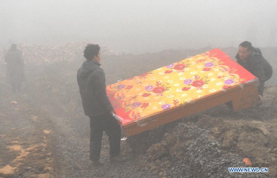 Villagers carry a mattress donated by a company in the makeshift tent area near the Gaopo Village in Zhenxiong County of Zhaotong City, southwest China's Yunnan Province, Jan. 14, 2013. Forty-six people died and 2 others injured in a landslide which hit the Zhaojiagou area of Gaopo Village around 8:20 a.m. on Jan. 11. More than 500 villagers have been moved to makeshift tents near the village. (Xinhua/Chen Haining)