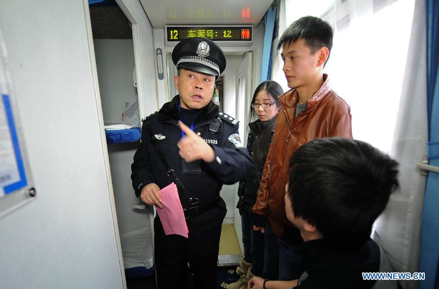 A railway policeman (L) explains safety matters to passengers on the Z124/Z122 express sleeper train from Chengdu to Shanghai in Chengdu, capital of southwest China's Sichuan Province, Jan. 15, 2013. The Z124/Z122 train from Chengdu to Shanghai, which started operation on Tuesday, is the first express sleeper train in southwest China and the fastest among all trains running between Chengdu and Shanghai. (Xinhua/Xue Yubin)