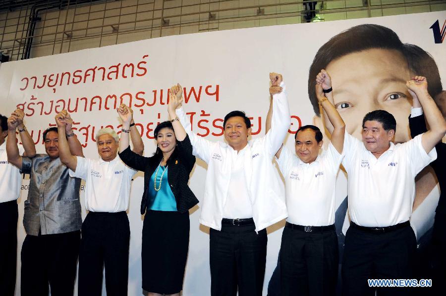 Thai Prime Minister Yingluck Shinawatra (4th R) and Bangkok Governor Candidate Pol Gen Pongsapat Pongcharoen (3rd R) hold hands at the Pheu Thai party headquarters in Bangkok, Thailand, Jan. 15, 2013. The Pheu Thai Party unveiled Bangkok Governor Candidate on Tuesday. (Xinhua/Rachen Sageamsak)