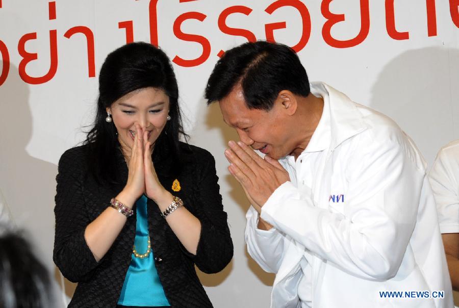 Thai Prime Minister Yingluck Shinawatra (L) and Bangkok Governor Candidate Pol Gen Pongsapat Pongcharoen greet each other at the Pheu Thai party headquarters in Bangkok, Thailand, Jan. 15, 2013. The Pheu Thai Party unveiled Bangkok Governor Candidate on Tuesday. (Xinhua/Rachen Sageamsak)