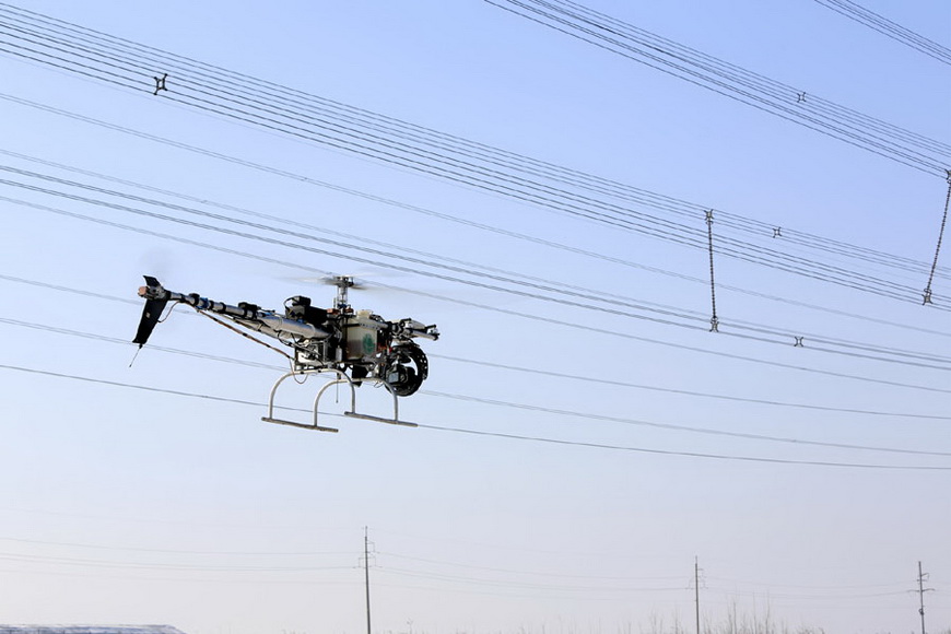 An unmanned helicopter inspects a 220-kV electric transmission line in Xiabo village, Jimo city, Shandong province, on Jan 9, 2013. (Photo/Xinhua) 