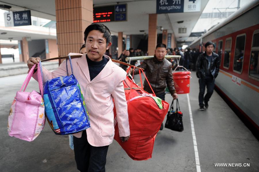 Migrant workers from southwest China's Chongqing prepare to board the train at the Hangzhou Railway Station in Hangzhou, east China's Zhejiang Province, Jan. 17, 2013. Some migrant workers have started to return home in order to avoid the Spring Festival travel peak that begins on Jan. 26 and will last for about 40 days. The Spring Festival, the most important occasion for a family reunion for the Chinese people, falls on the first day of the first month of the traditional Chinese lunar calendar, or Feb. 10 this year. (Xinhua/Ju Huanzong) 