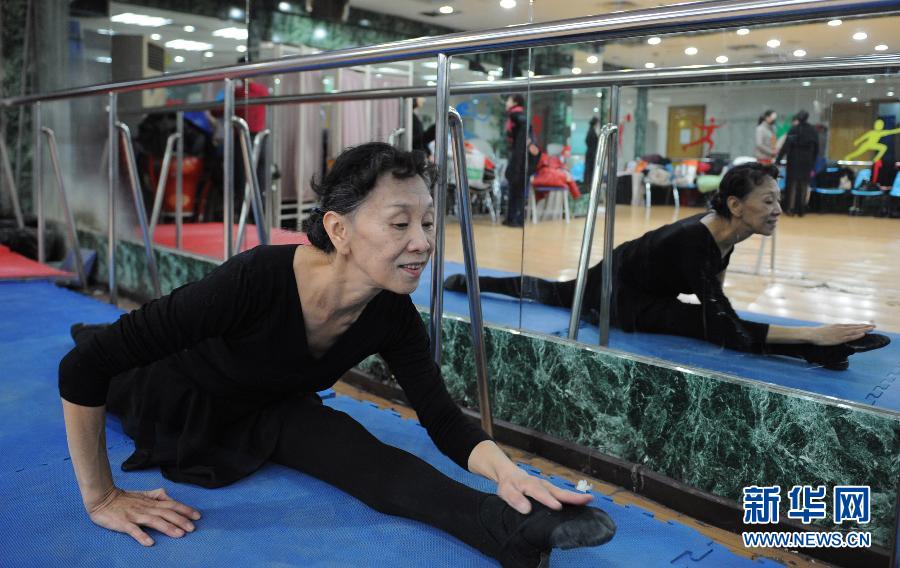 Wang Zheng, 56, warms up before dancing in the dressing room in the National Grand Theater on Jan. 15, 2013. (Photo/Xinhua)