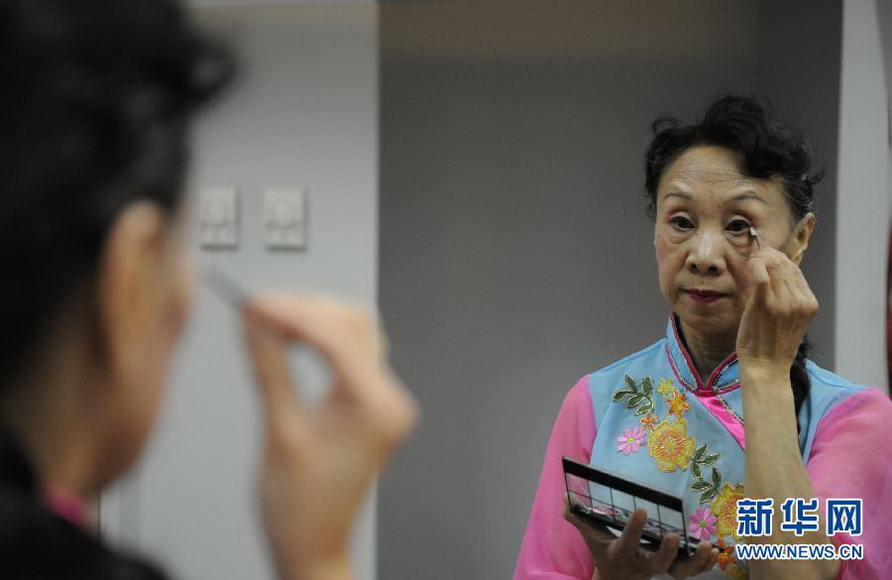 Li Kailin, 66, makes up before rehearsal in the National Grand Theater on Jan. 15, 2013. (Photo/Xinhua)