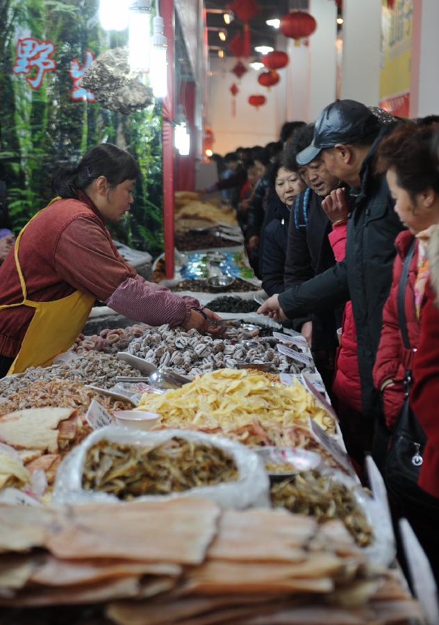 People buy dried fruits during the second Guiyang spring festival shopping fair in Guiyang, capital of southwest China's Guizhou Province, Jan. 19, 2013. The fair which would last from Jan. 19 to Feb. 6 attracts the participation of more than 400 enterprises, providing special goods for the Spring Festival use. (Xinhua/Tao Liang) 
