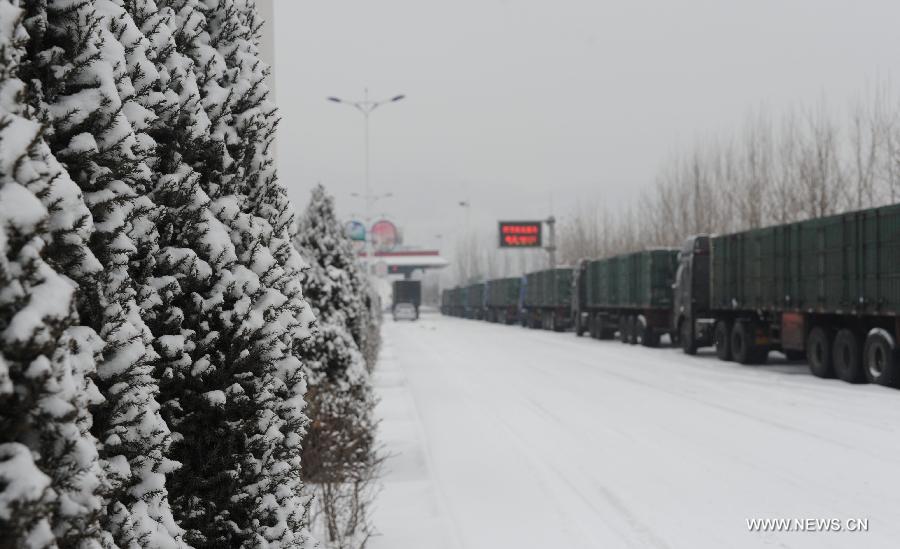 Trucks queue outside the entrance of the Beijing-Kunming Expressway due to highway closure in Tangxian County, north China's Hebei Province, Jan. 20, 2013. Snow fell in most parts of Hebei Province on Jan. 19 evening and 19 expressways in the province have been closed. (Xinhua/Zhu Xudong) 