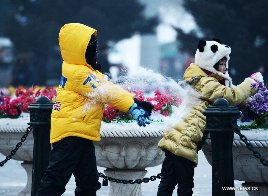 Children play with snow in Harbin, capital of northeast China's Heilongjiang Province, Jan. 20, 2013. The temperature rise in Harbin enabled citizens to play with snow and ice in the outdoors. (Xinhua/Wang Kai)  