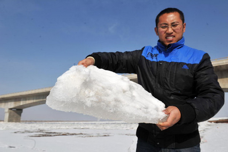 A man shows a block of drift ice taken from the Yinchuan section of the Yellow River in Northwest China's Ningxia Hui autonomous region, on Jan 21, 2013. (Photo/Xinhua) 