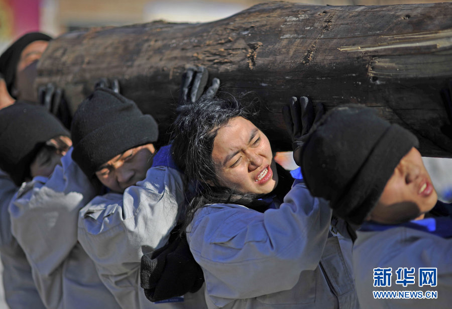 Team members carry a 400-kilogram log by shifting it between left and right shoulders.(Photo/Xinhua)