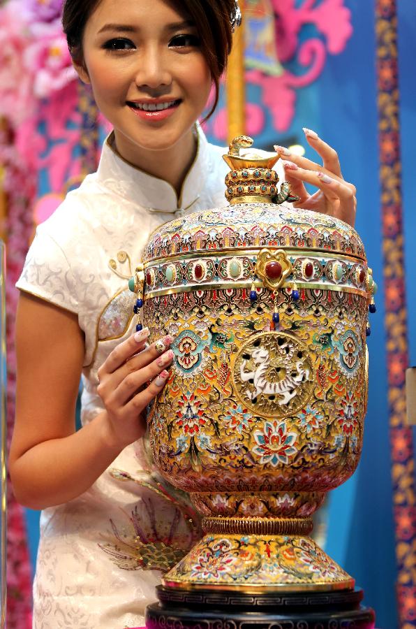 A piece of cloisonne work made by artist Zhang Tonglu is presented by Elva Ni, the winner of 2005 Miss Chinese Toronto Pageant, during an exhibition in south China's Hong Kong, Jan. 22, 2013. An exhibition of Zhang Tonglu's cloisonne art works was held here on Tuesday, showing 22 pieces of cloisonne works. (Xinhua/Li Peng) 