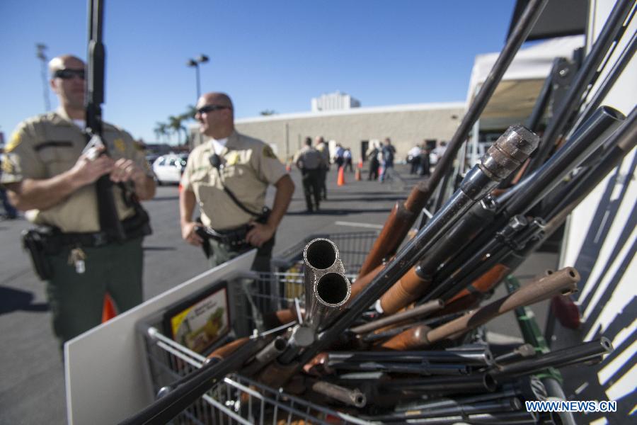 Reclaimed rifles are put in a shopping cart as Los Angeles County Sheriff's deputies get weapons back from motorists during a "Gifts For Guns" exchange program in Los Angeles, California, the United States, Jan. 21, 2013. People can turn in a firearm and receive a gift card of 200 U.S. dollars for an assault weapon, 100 U.S. dollars for a handgun, and 50 U.S. dollars for a shotgun. (Xinhua/Zhao Hanrong)  