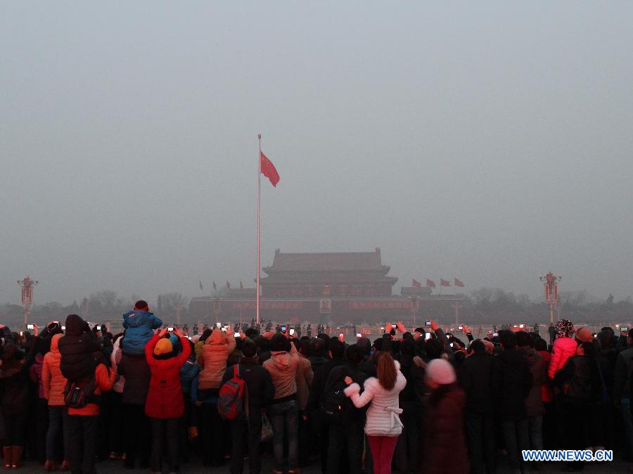 Tourists watch the national flag-raising ceremony at the fog-enveloped Tian'anmen Square in Beijing, capital of China, Jan. 23, 2013. The air quality hit the level of serious pollution in Beijing on Wednesday, as smog blanketed the city. (Xinhua/Wang Yueling) 