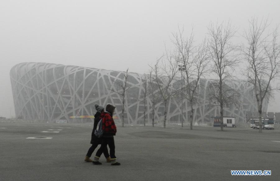 Citizens walk past the fog-enveloped National Stadium, or the "Bird's Nest", in Beijing, capital of China, Jan. 23, 2013. The air quality hit the level of serious pollution in Beijing on Wednesday, as smog blanketed the city. (Xinhua/Wang Zhen)