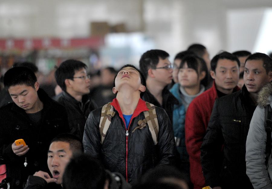 A student is seen relaxing in the waiting hall of the Hefei Train Station in Hefei, capital of east China's Anhui Province, Jan. 23, 2013. Hefei witnessed a student travel peak as winter holidays started in recent days. (Xinhua/Guo Chen) 