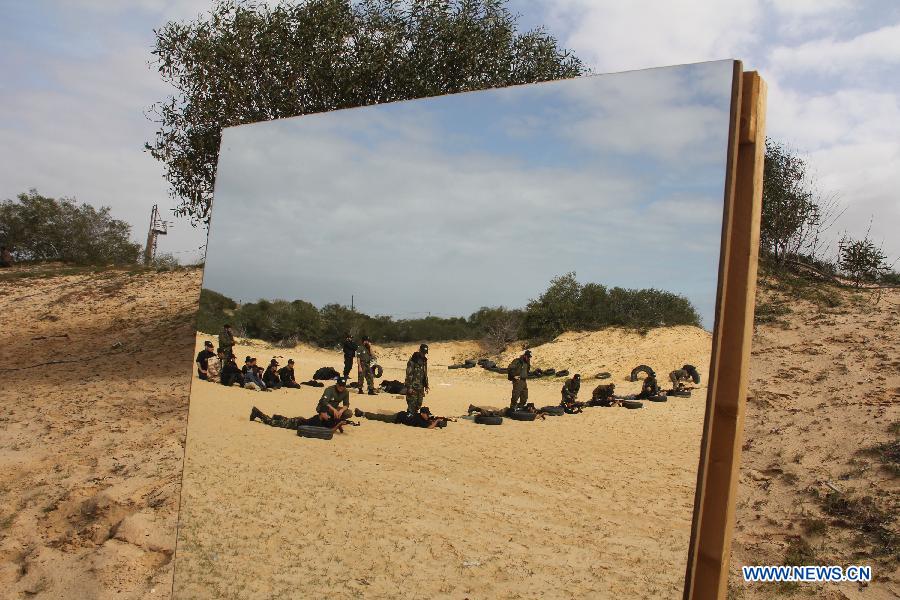 Palestinian students are seen through the reflection on a mirror to take part in a paramilitary training organized by Hamas National Security in the southern Gaza Strip city of Rafah on Jan. 23, 2013. (Xinhua/Khaled Omar)