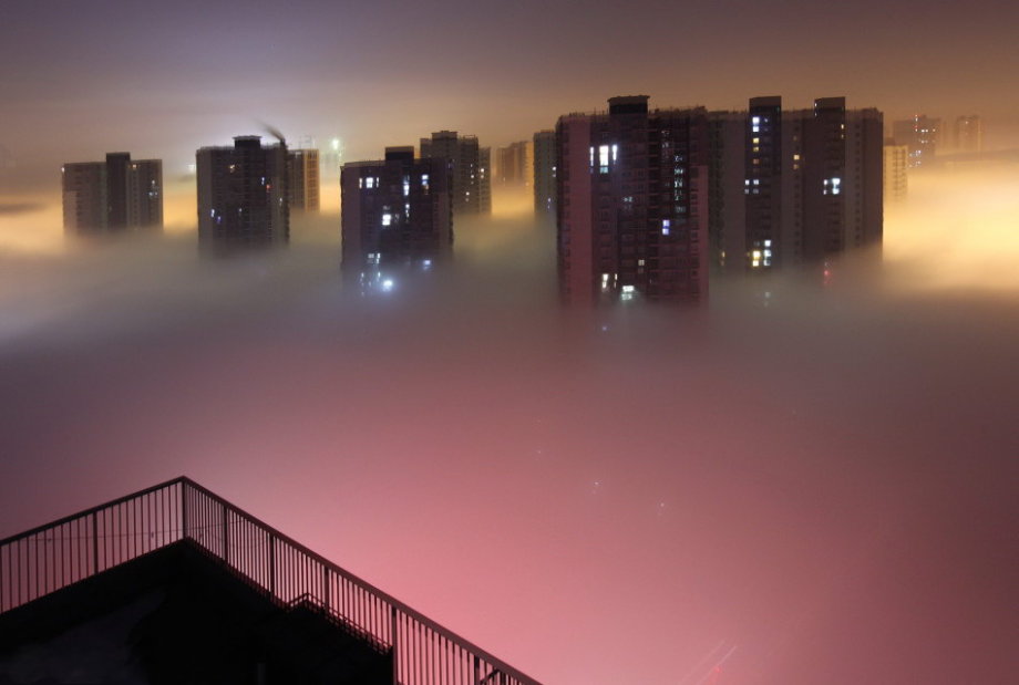 Dense fog hit back Beijing and caused serious air pollution on Tuesday and Wednesday. From the bird’s-eye view, the sleeping city was shrouded by fantasy created by shimmer of dawn, illumination and fog. (Photo/CCTV) 