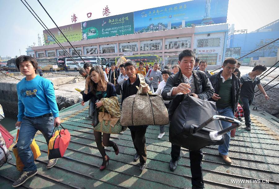Passengers prepare to board a ship at the Xiuying Port in Haikou, capital of south China's Hainan Province, Jan. 24, 2013. Haikou witnessed a travel rush on Thursday as the Spring Festival draws near. (Xinhua/Guo Cheng)