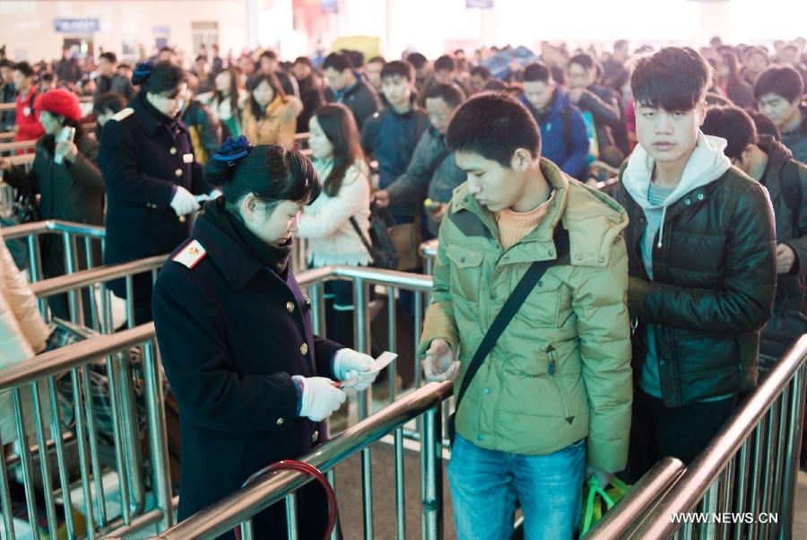 Passengers get their tickets checked at Chongqing North Railway Station in southwest China's Chongqing Municipality, Jan. 24, 2013. As the Spring Festival approaches, more and more people started their journey home. (Xinhua/Liu Chan)