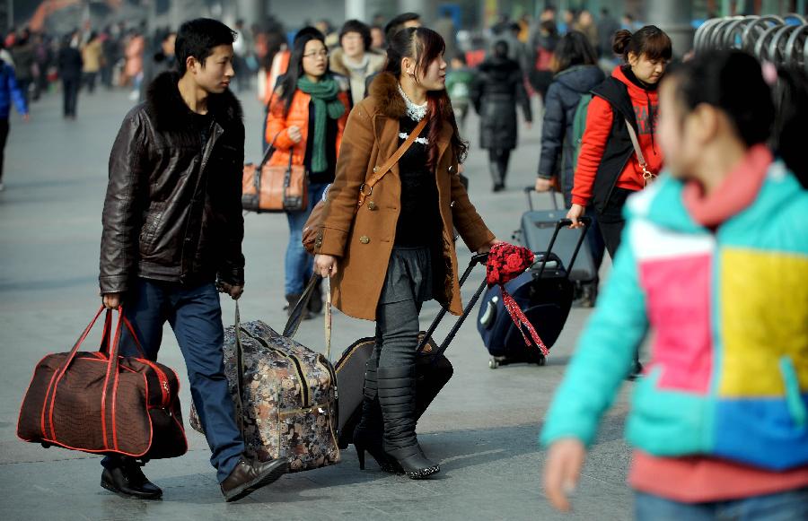Passengers walking with their luggage on the square of the train station in Chengdu, capital of southwest China's Sichuan Province, Jan. 24, 2013. As the spring festival approaches, more than more people started their journey home. (Xinhua/Xue Yubin)