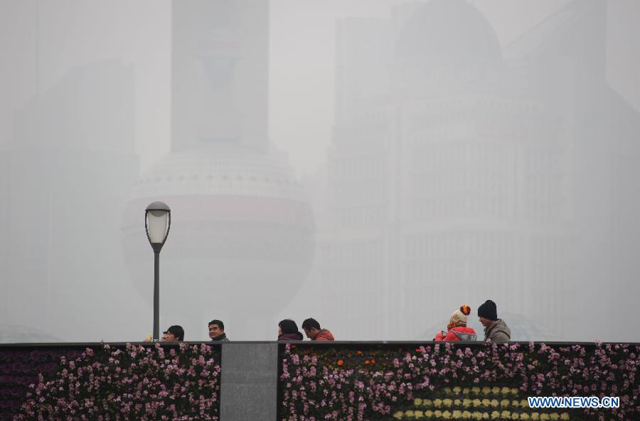 Tourists visit the Bund in the fog in east China's Shanghai Municipality, Jan. 24, 2013. Fog hit Shanghai Thursday. (Xinhua/Lai Xinlin)