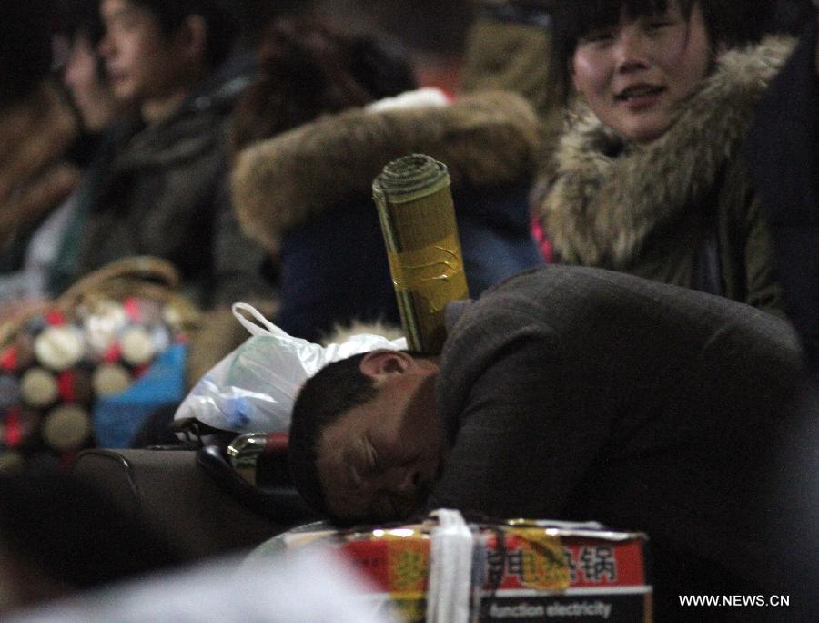 A passenger has a nap while waiting for his train at the Changzhou Railway Station in Changzhou City, east China's Jiangsu Province, Jan. 26, 2013. The 40-day Spring Festival travel rush started on Saturday. The Spring Festival, which falls on Feb. 10 this year, is traditionally the most important holiday of the Chinese people. It is a custom for families to reunite in the holiday, a factor that has led to massive seasonal travel rushes in recent years as more Chinese leave their hometowns to seek work elsewhere. Public transportation is expected to accommodate about 3.41 billion travelers nationwide during the holiday, including 225 million railway passengers, (Xinhua/Chen Wei) 