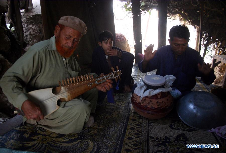 Local residents play traditional music on roadside in northwest Pakistan's Peshawar on Jan. 27, 2013. (Xinhua/Ahmad Sidique)