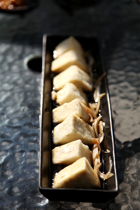 Fried tofu triangles served with the traditional onion sauce (Photo by Fan Zhen/China Daily)